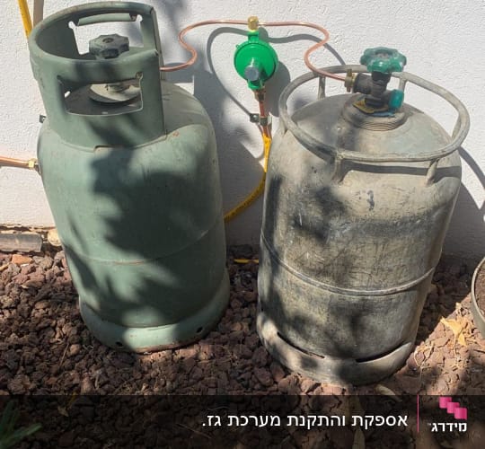 שני בלוני גז עם וסתים וצינורות חיבור